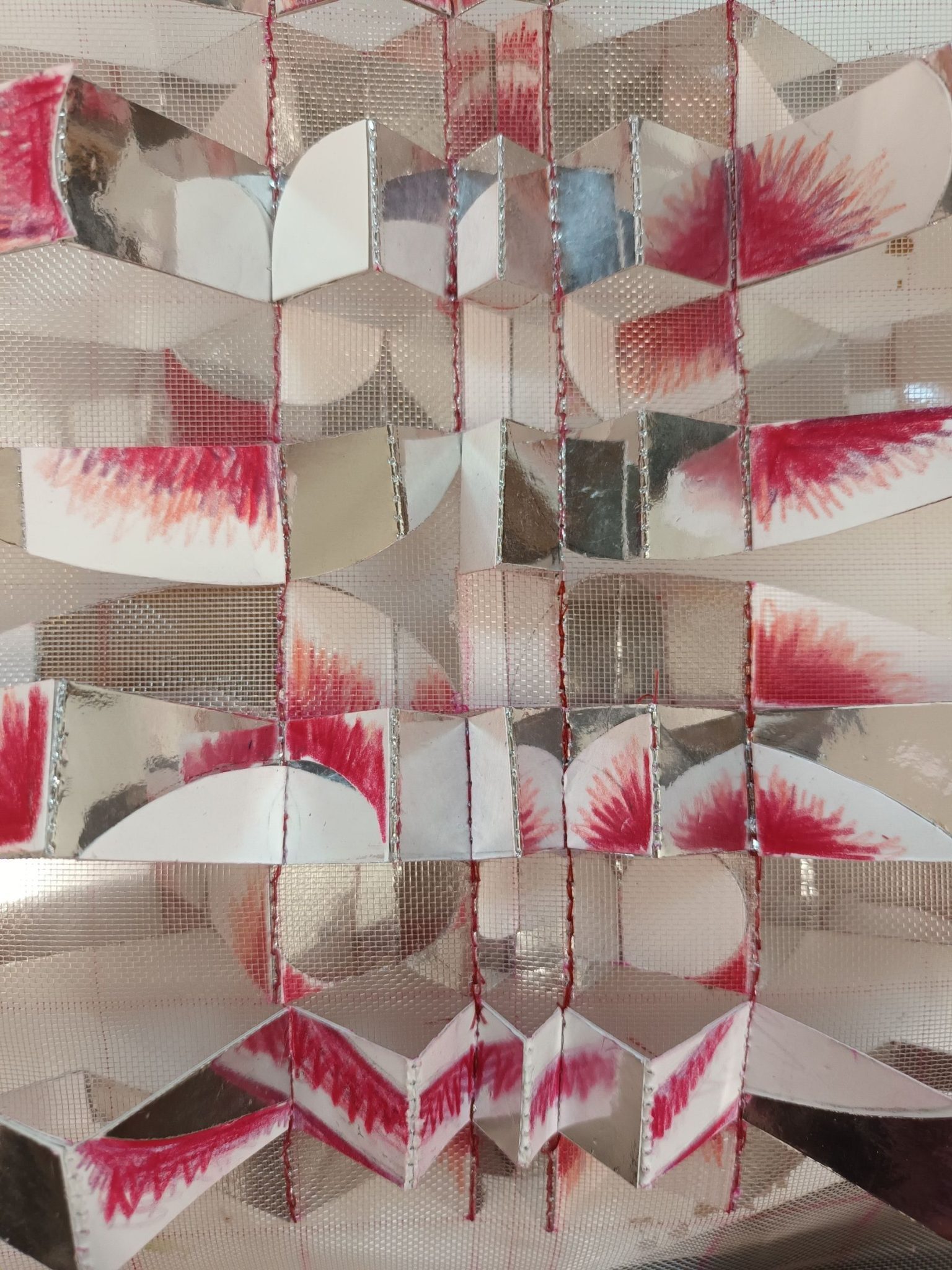 Paper, gauze and mirror card stitched in a zig zag shape.