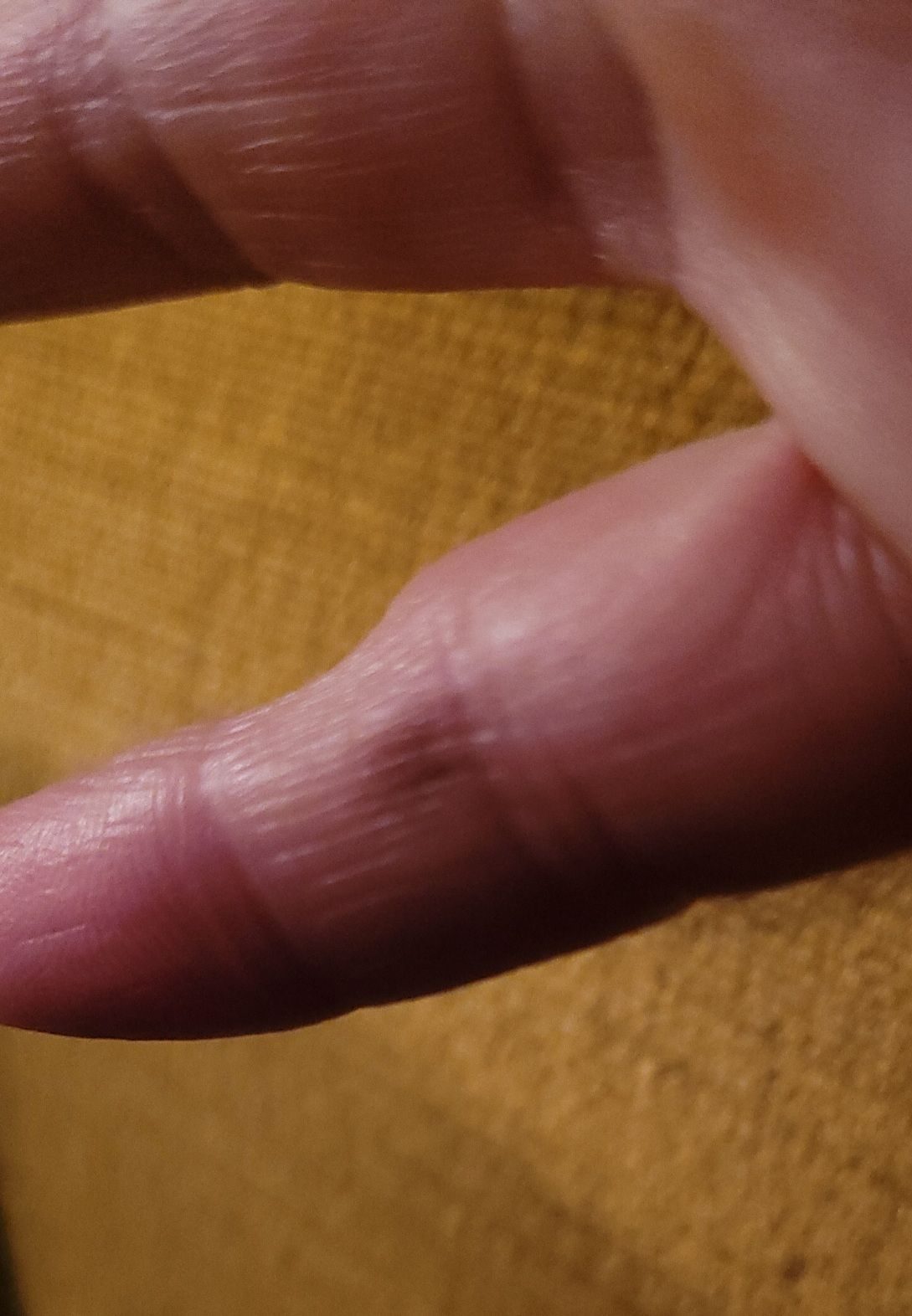 Detail of a hand on yellow velvet