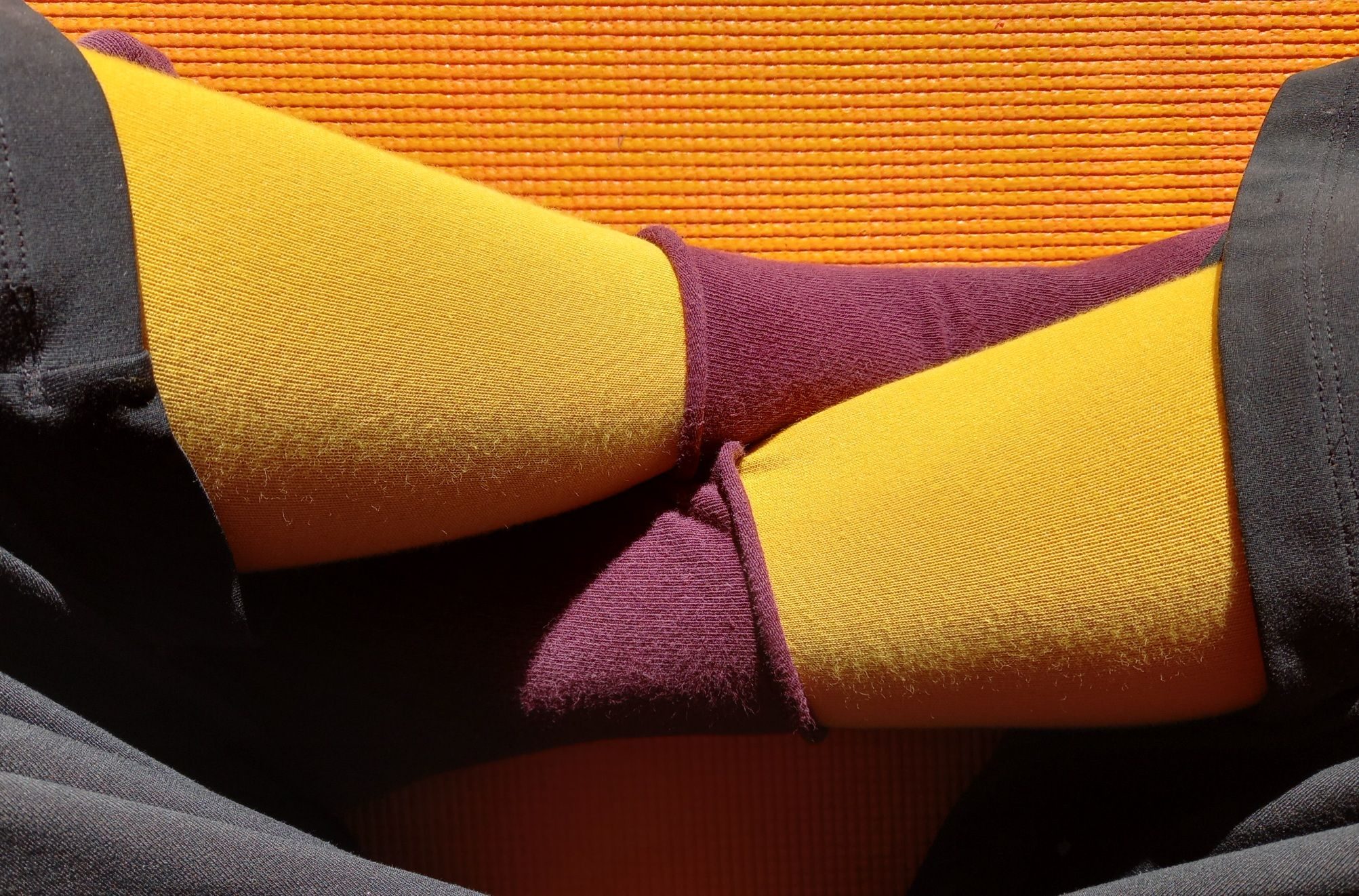 Photograph of crossed legs with coloured socks