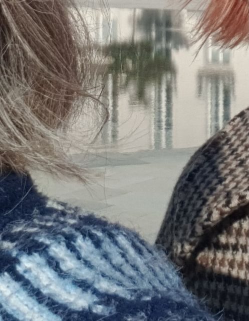 detail of fairisle jumper, grey hair, checked cloak and dyed red hair