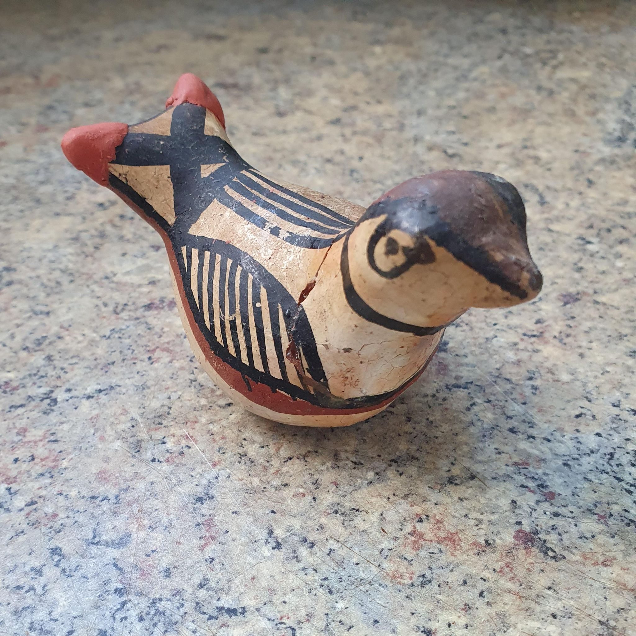 small bird made of clay had broken tip of wings. Repaired with clay and a bit of acrylic colour.