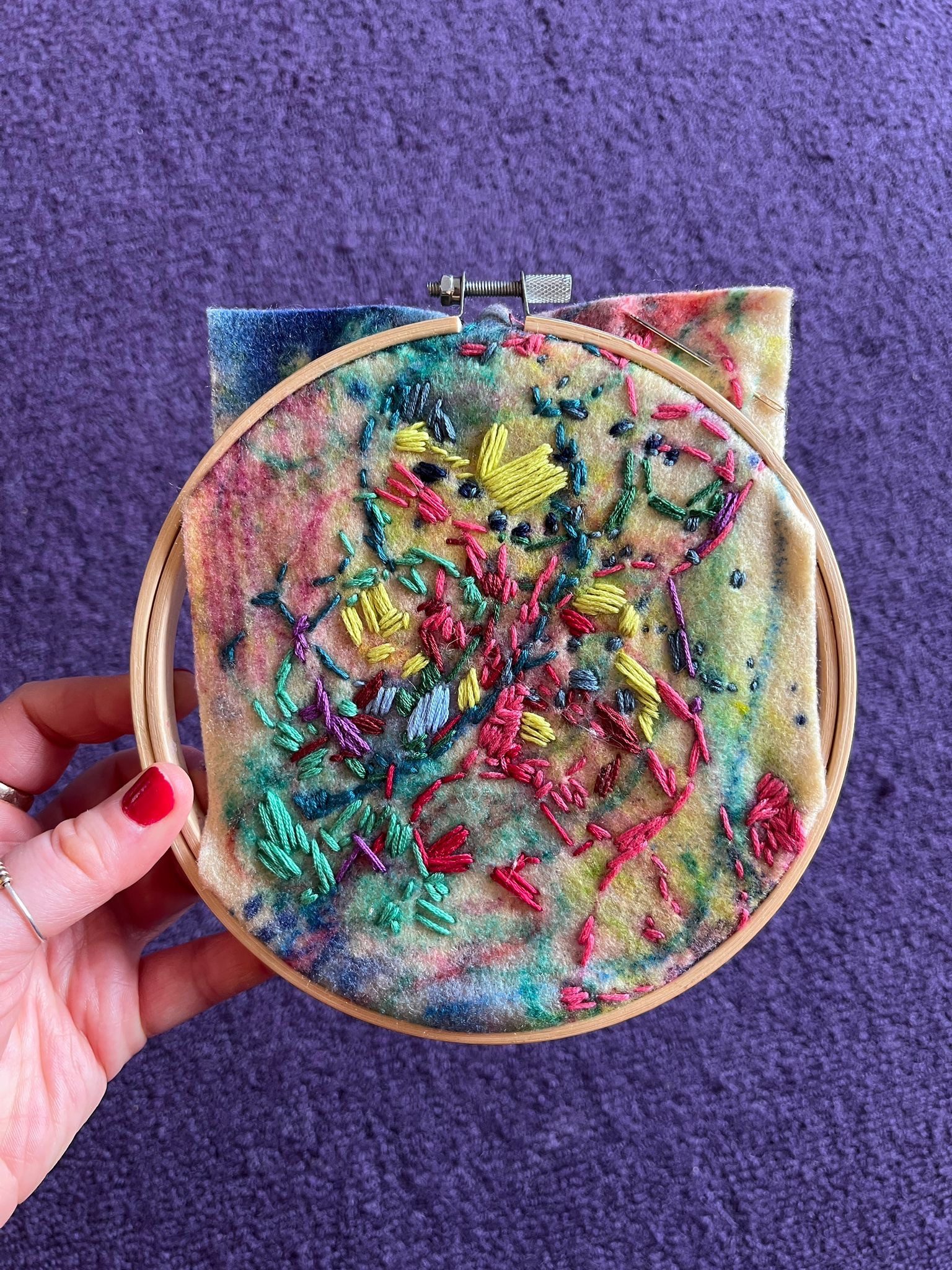 Colourful embroidery over expressive marks, on felt