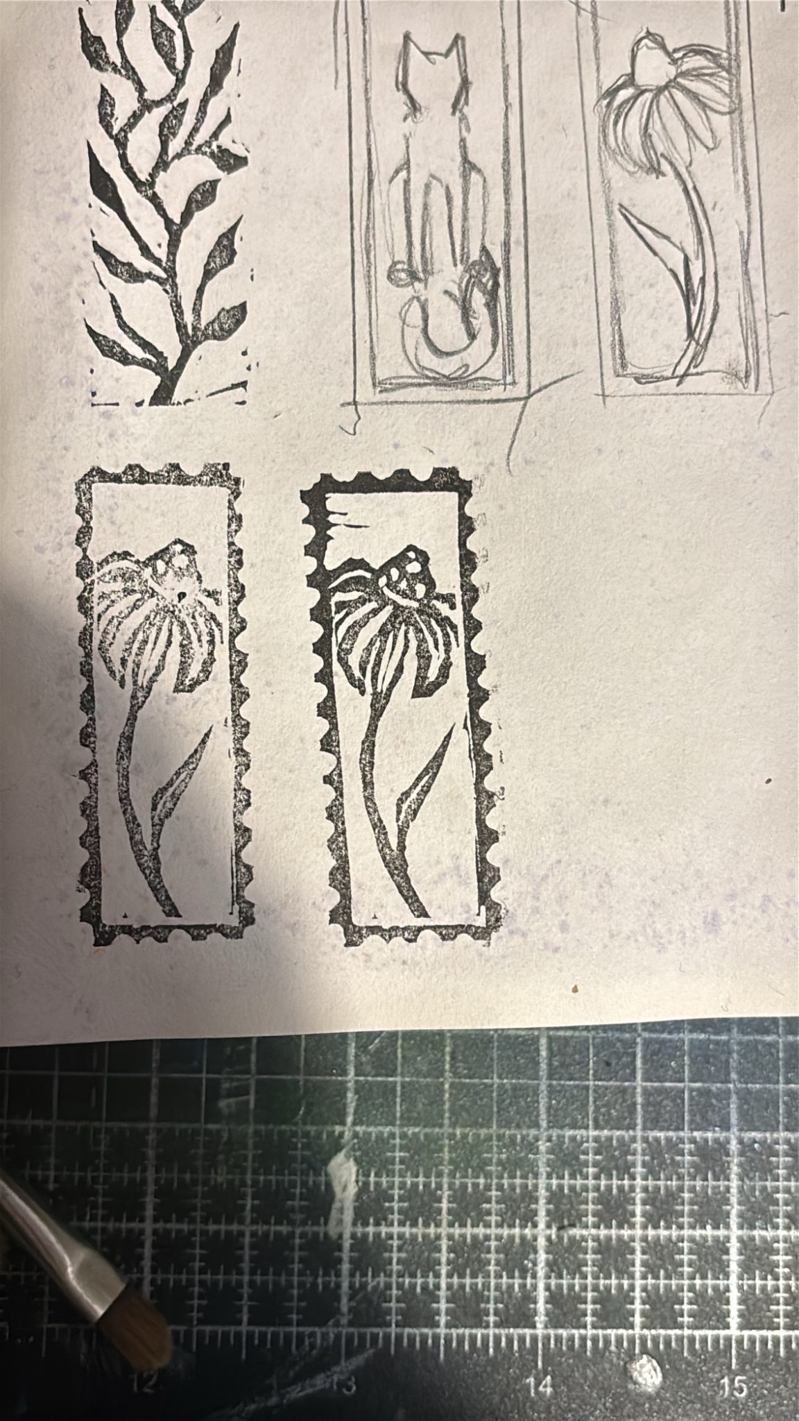 A small rubber sized lino print of a flower with a conical centre and petals pointing downwards, framed by a stamp edge pattern
