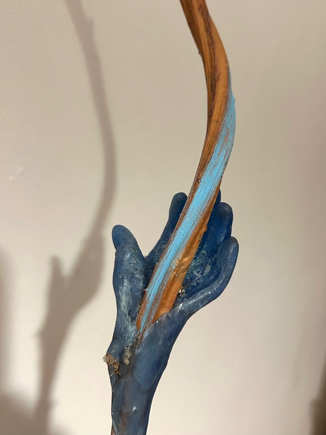 Blue wax hand with dried twisted bramble coming out of the palm