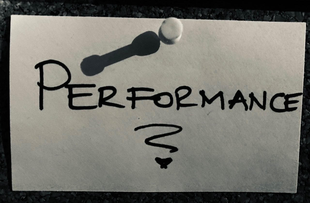 Photograph of the word Performance written out and pinned to a board