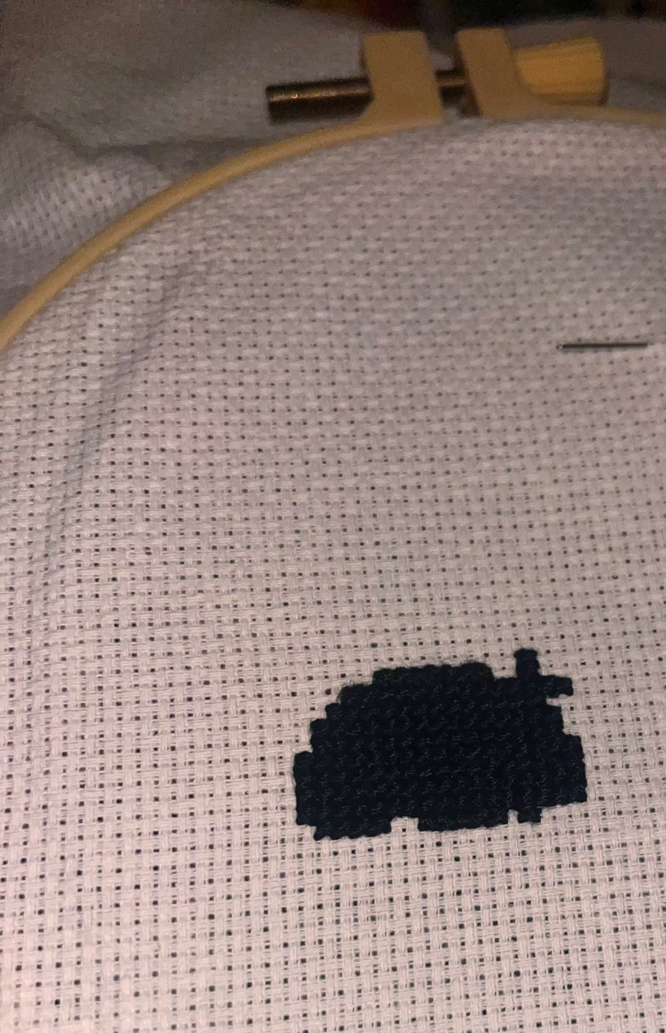 An unfinished black and white cross stitch