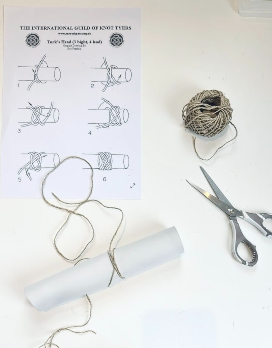 trying to follow a knot diagram using string around a light grey porcelain tube - a stop motion video shows it is not completed