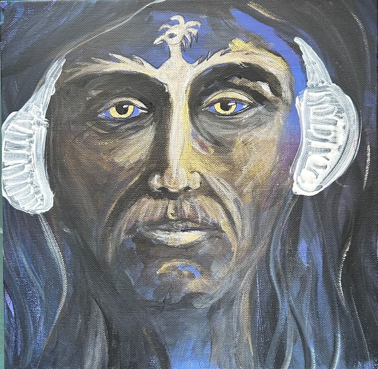 Man with headphones and phoenix tattoo on his face.