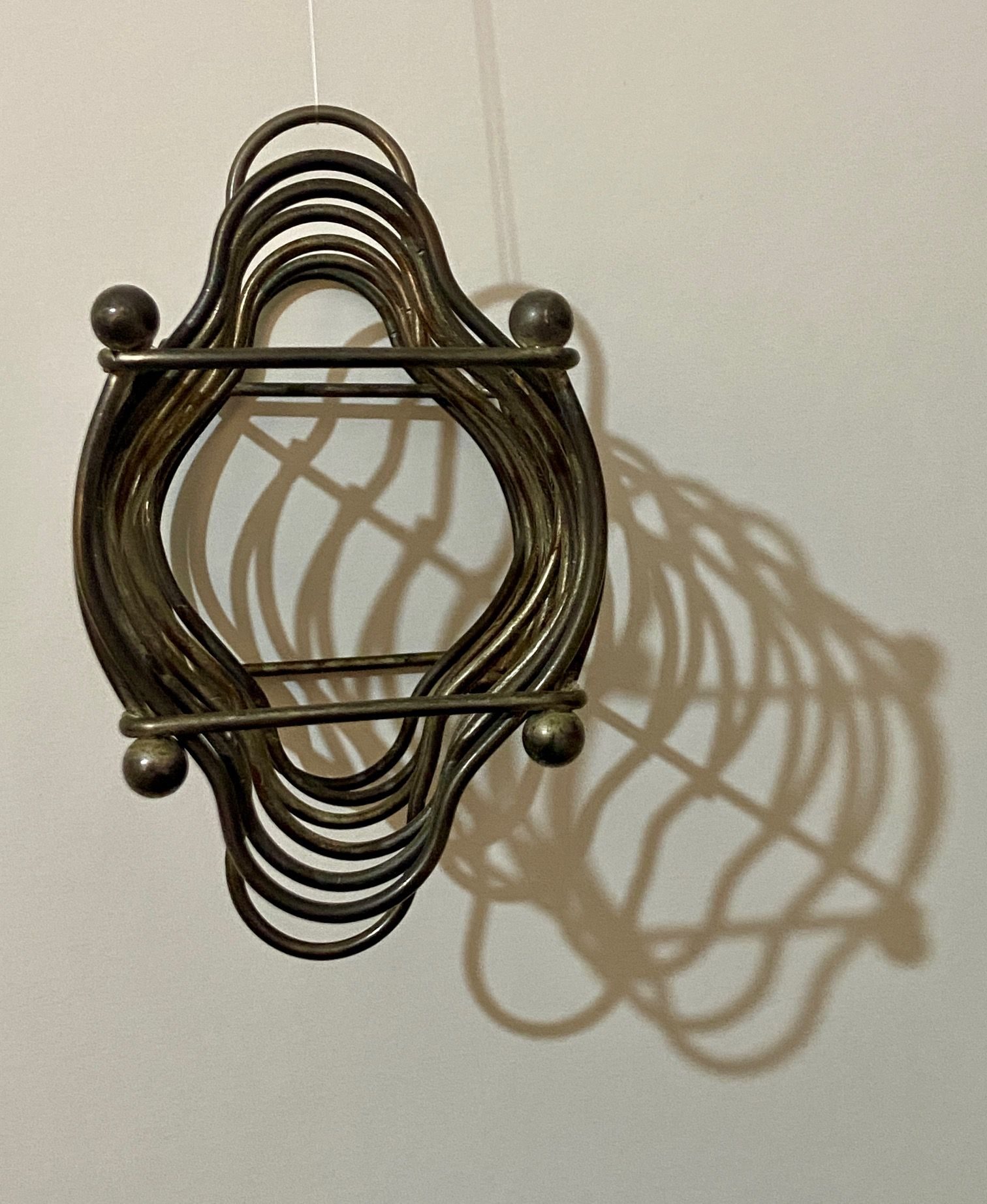 2 metal toast racks, stacked together, showing their combined shadows