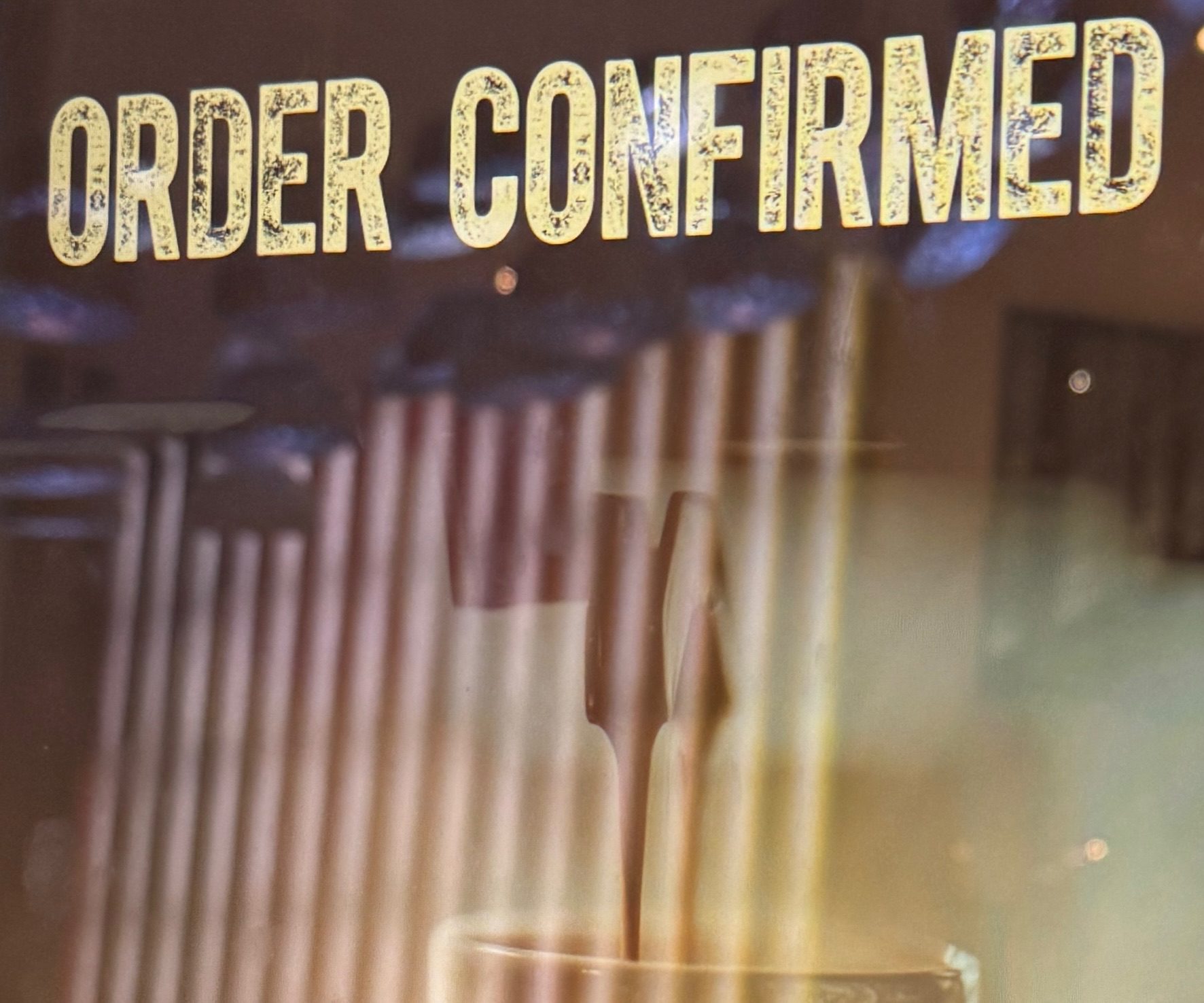 Order confirmed for a coffee. Abstract reflections in the glass of the screen that gives confirmation.
