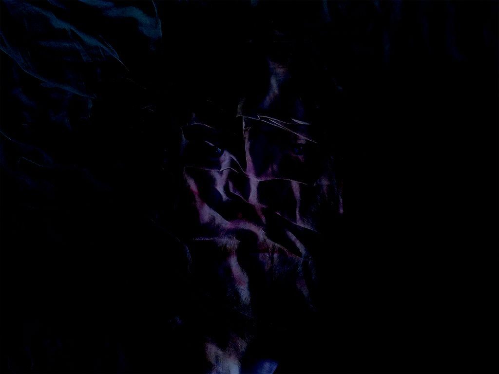 Photo montage of a distorted blue face on creased bedsheets