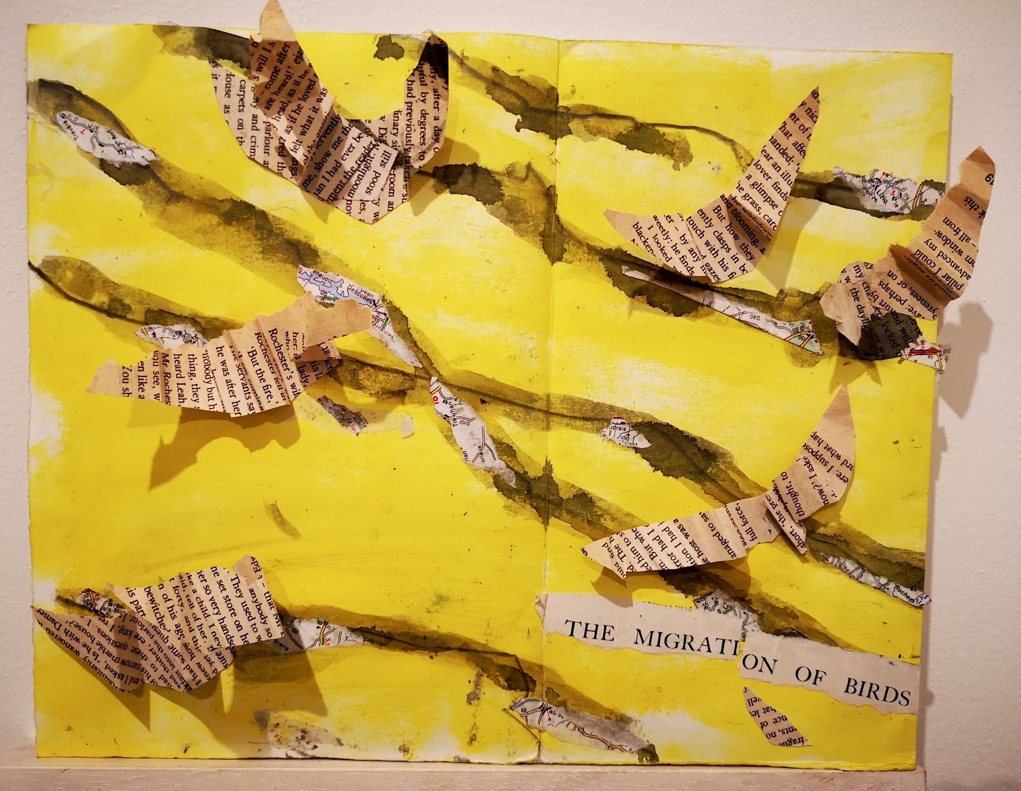 a collage of flying birds made from text newspaper against a yellow backdrop with flying paths marked in blue watercolour