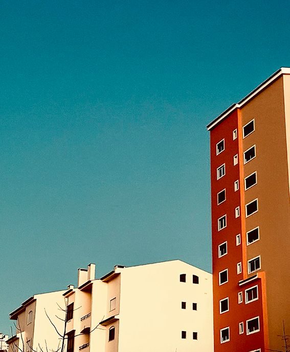 Photo of blue sky and orange and white buildings