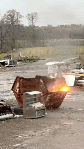 Gif showing a skip with flames exploding out of it