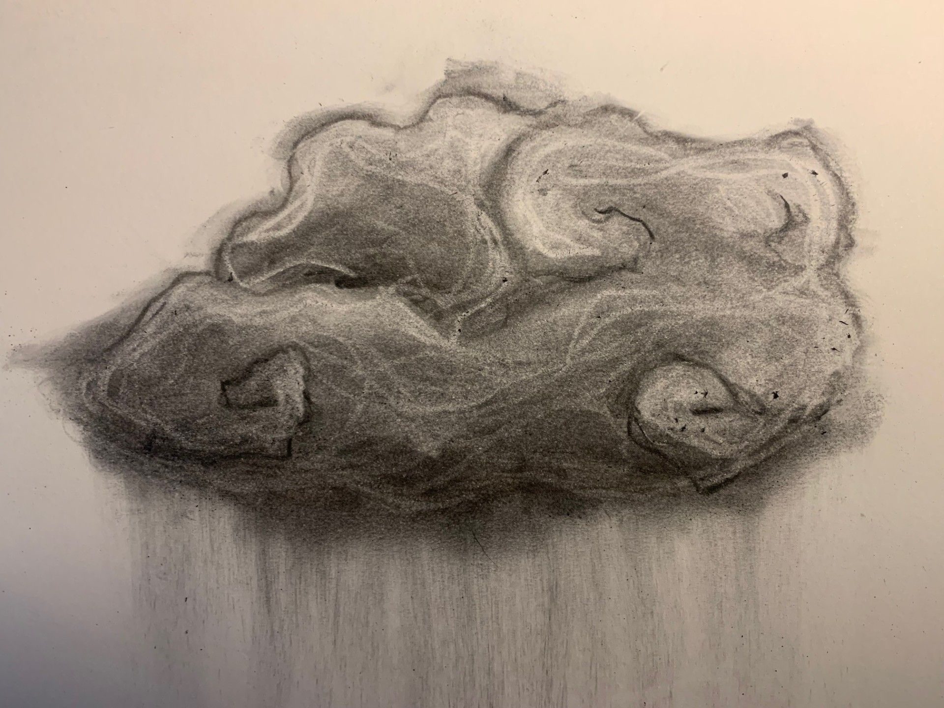 A stylized charcoal drawing of a cloud with charcoal powder pouring out as rain.