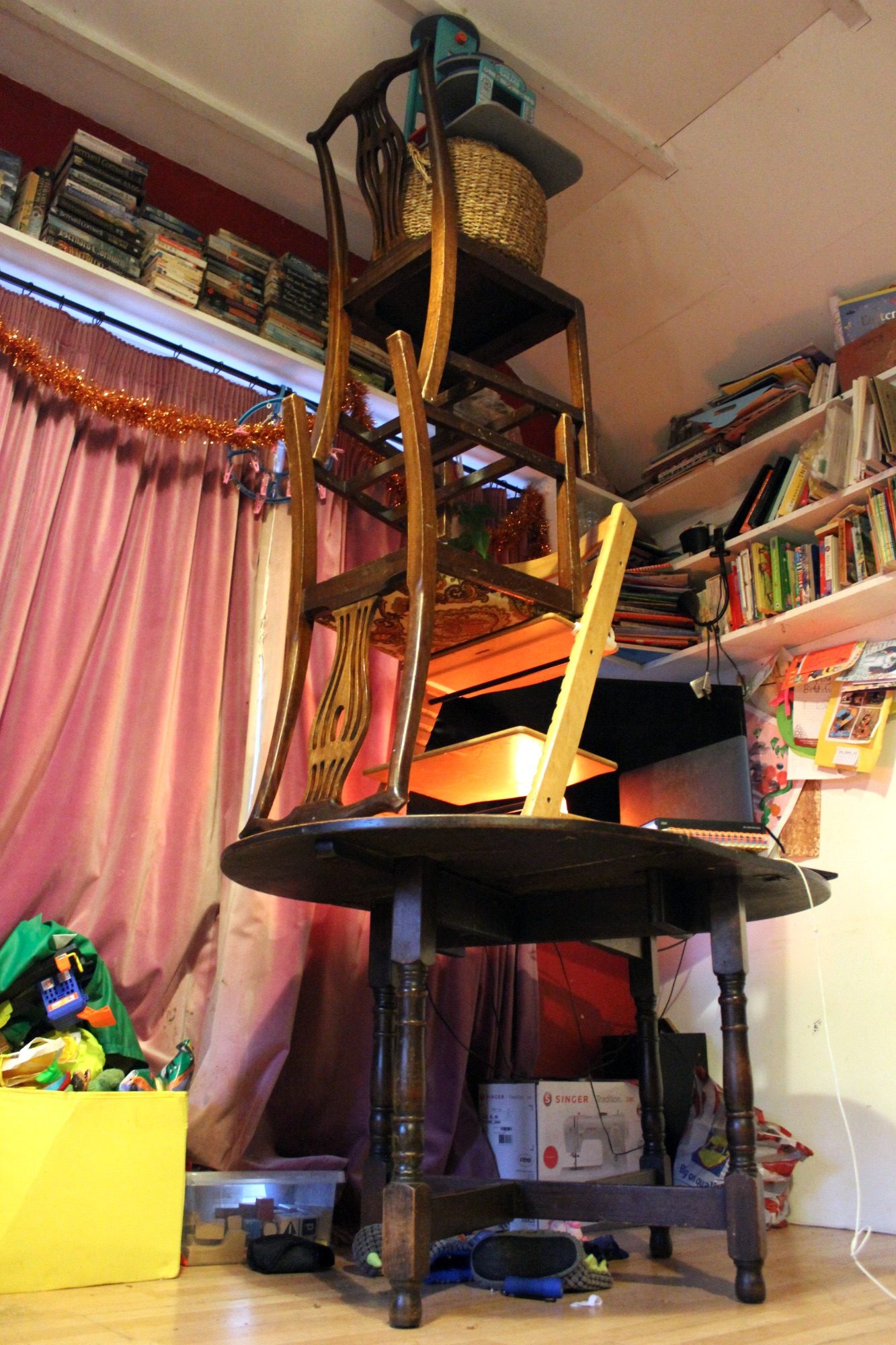 Pile up of stuff so it spans floor to ceiling - table, chairs, basket and toys.