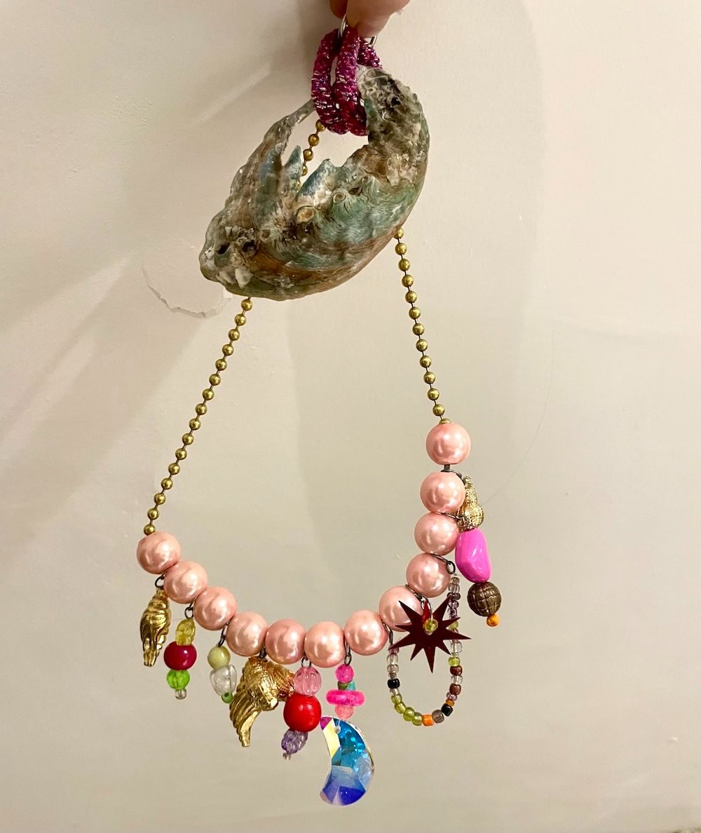 Stuff hanging with a crystal moon, old shell and a hairtie