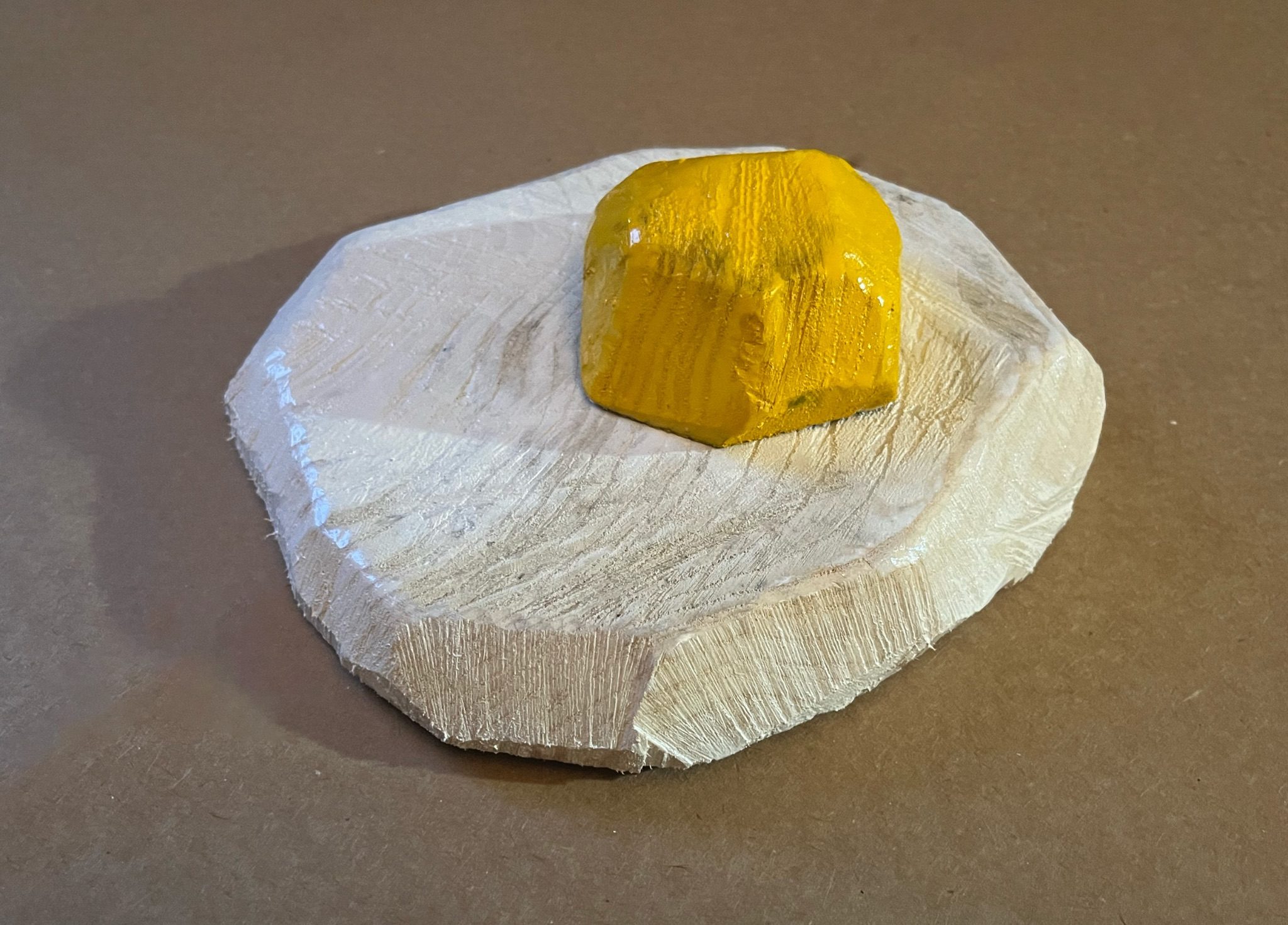 A fried egg carved from a found piece of wood
