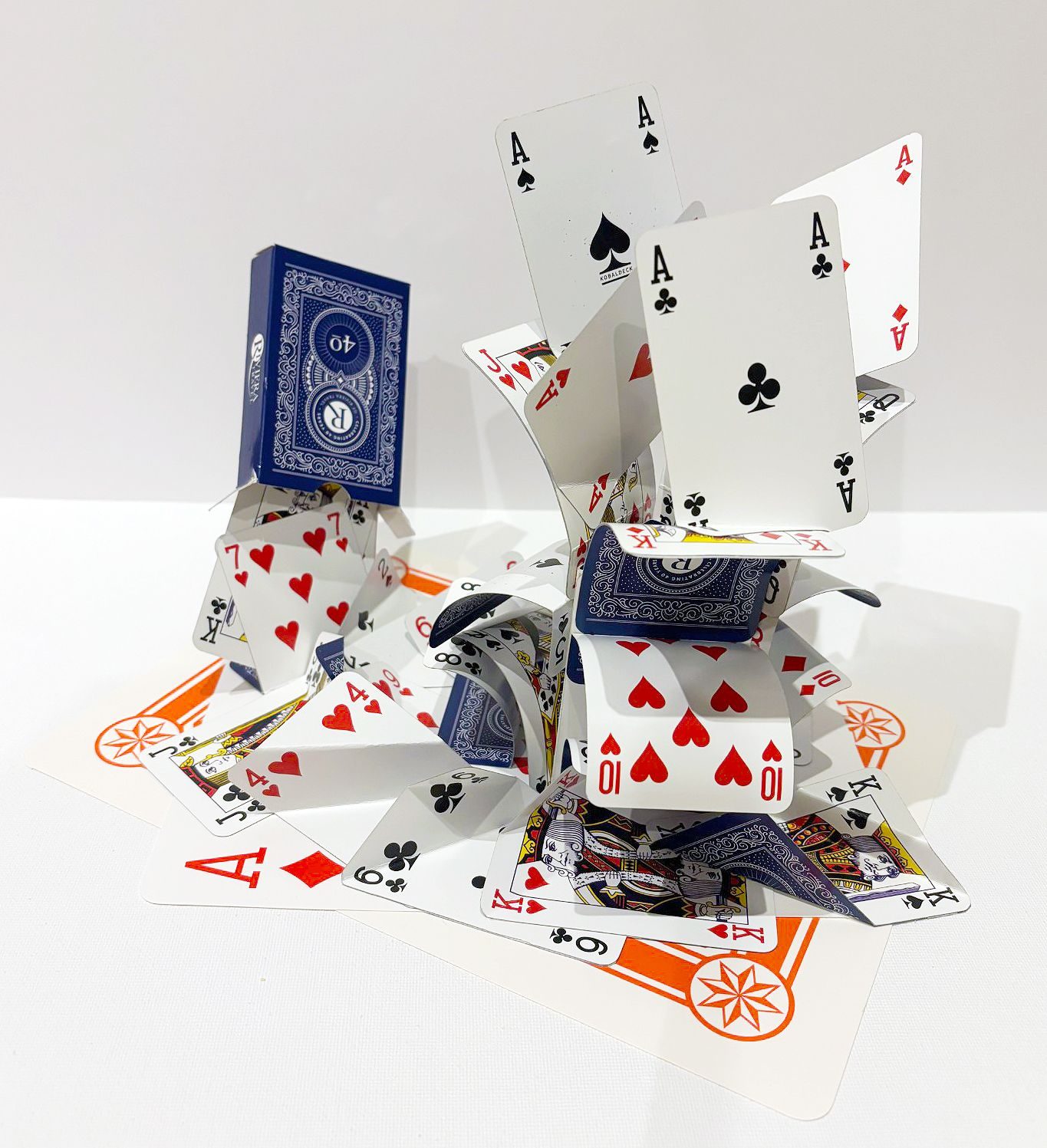 A pack of playing cards is emptying creating a fountain of cards with prominent aces.