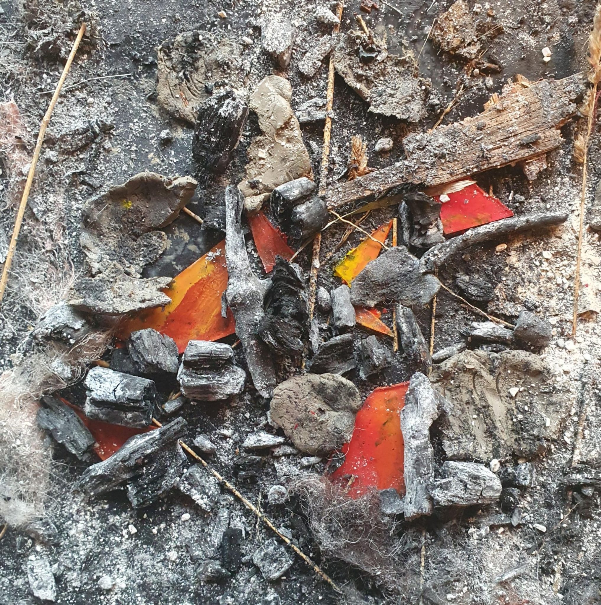 Ashes, pieces of coal, dry grass and shards of glass with acrylic put on reverse to get a shine