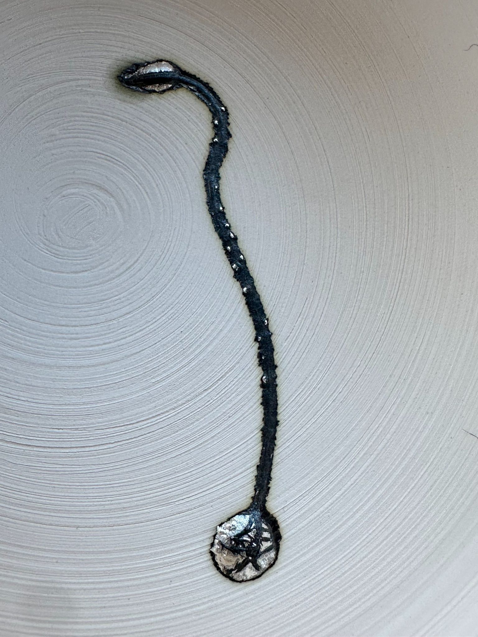 Silver pin fired to bisque on porcelain clay