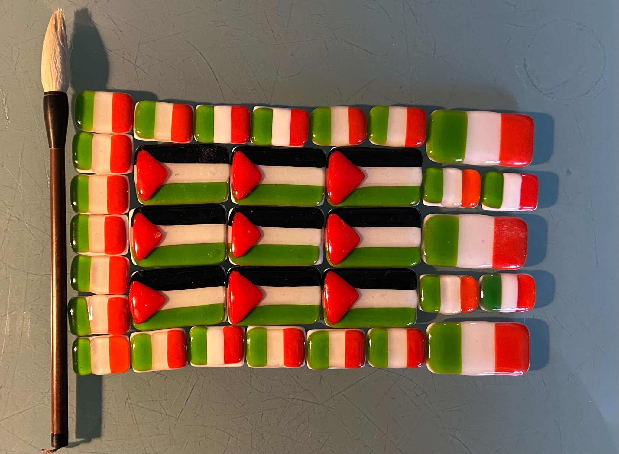 Irish flags around Palestinian flags made of fused glass - showing solidarity - Paintbrush is artists