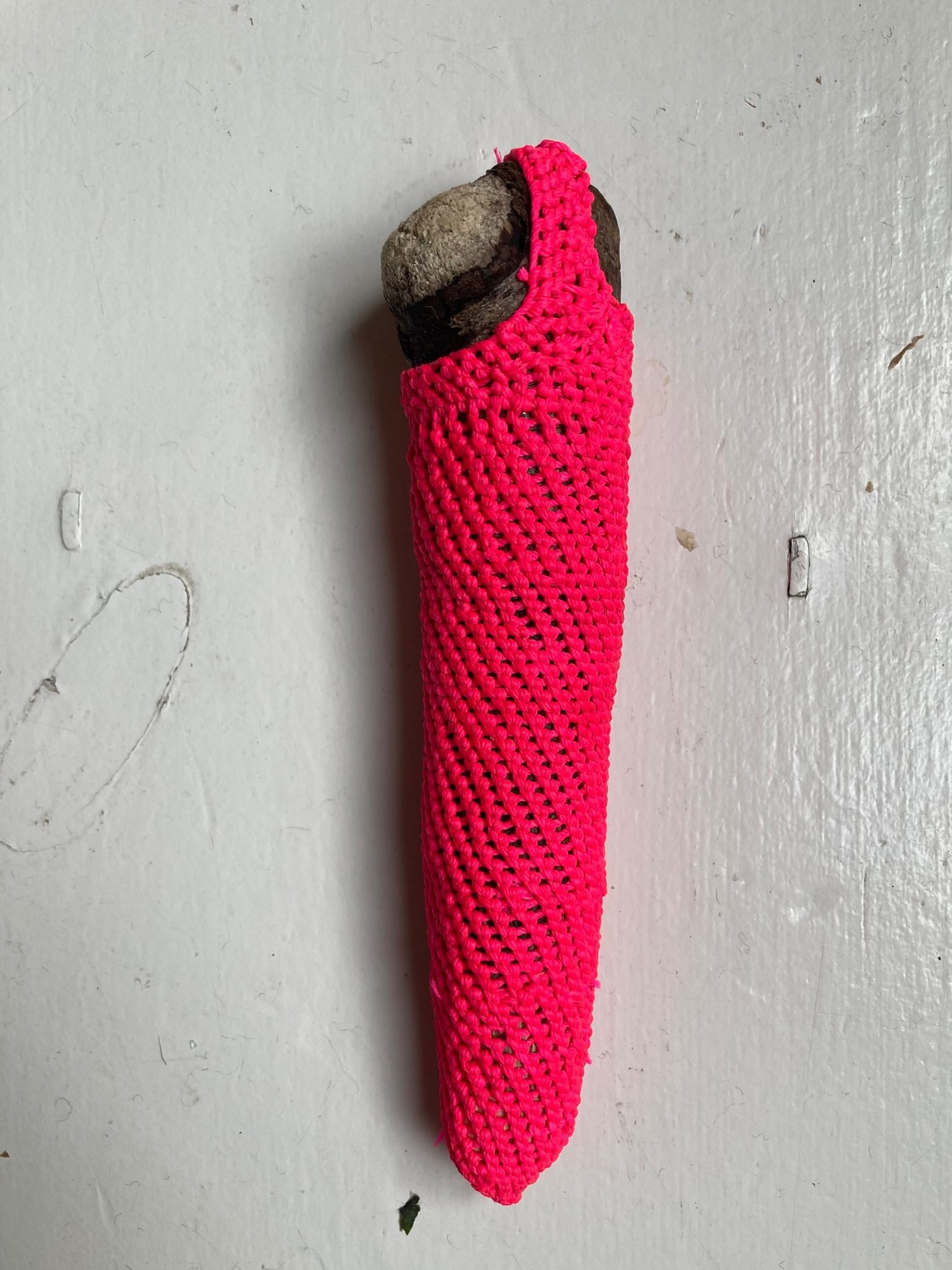 Note shaped drift wood knotted over with pink thread