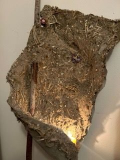 rough cob flag on a stick with a few badges that are hard to make out ..one is a diamanté horse shoe and one is a horse in a fold is a candle illuminating