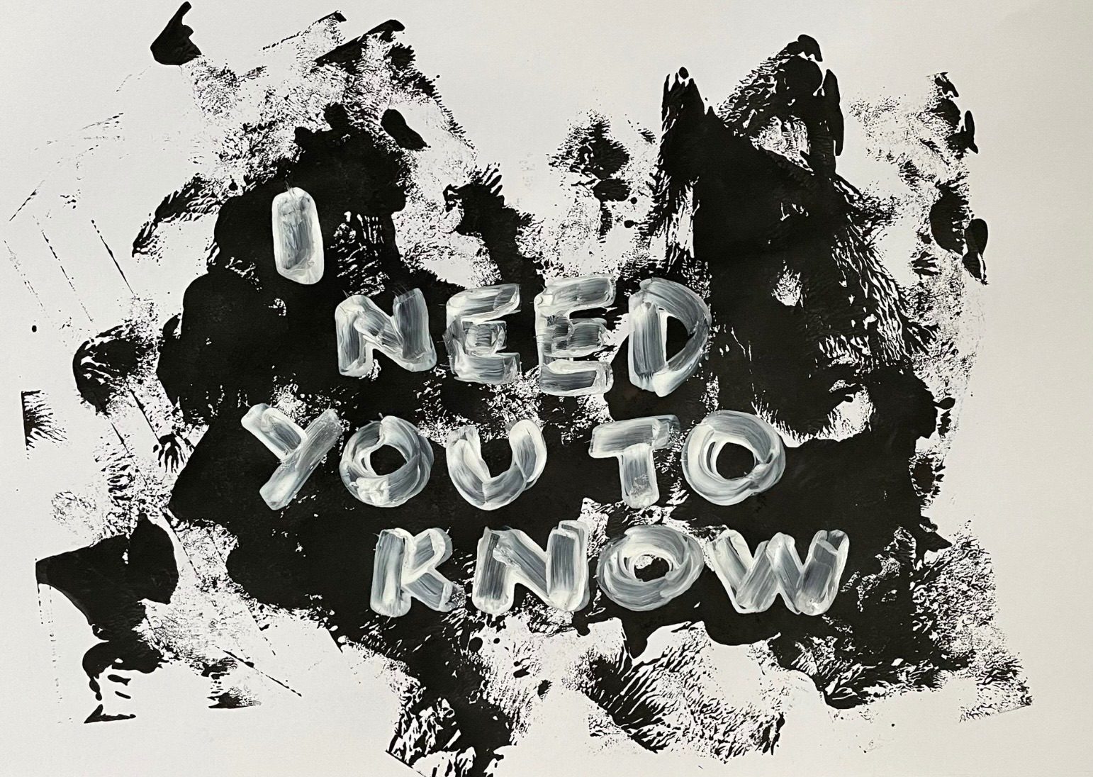 Landscape black and white: black paint splats in the background, foreground has hand painted white text ‘I need you to know’