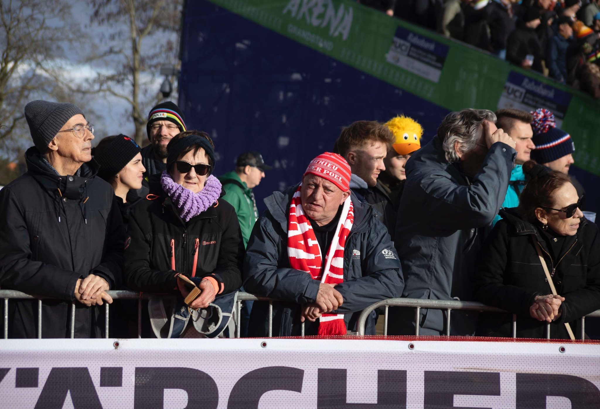 Two spectators directly address the camera