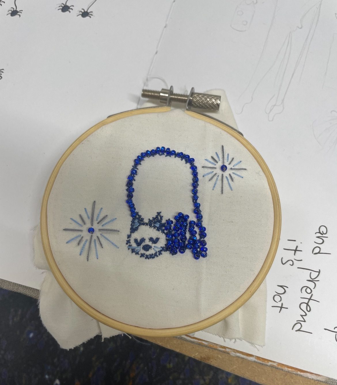 A little embroidery piece of a cat and blue beads
