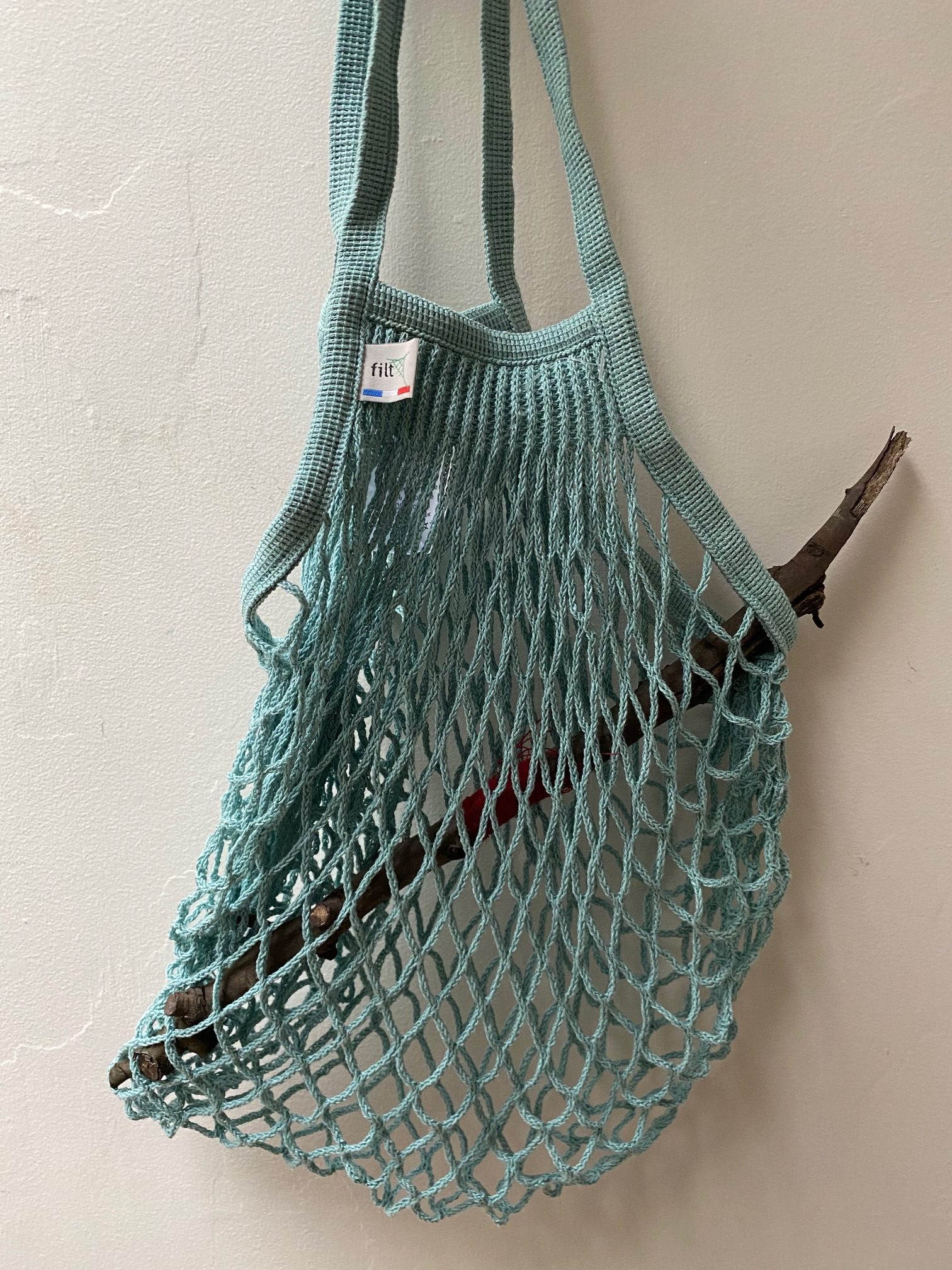 Woven shopping bag containing a long stick