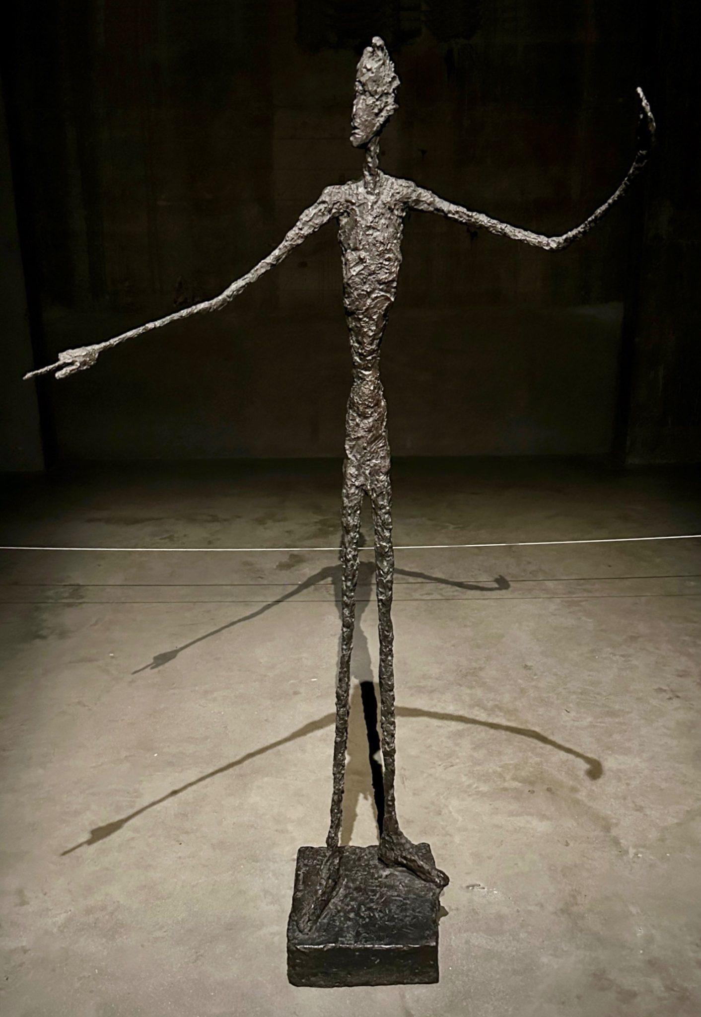 Photograph of Modagliani sculpture of figure with raised arms. The shadows have two pairs of arms (due to lighting)