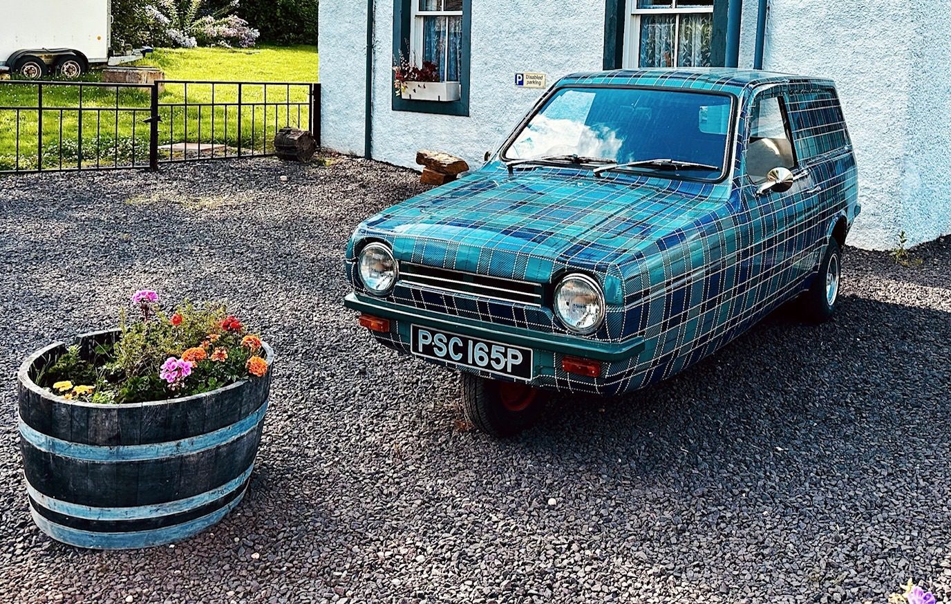 Photograph of Reliant three-wheeled car with bodywork painted in Tartan pattern