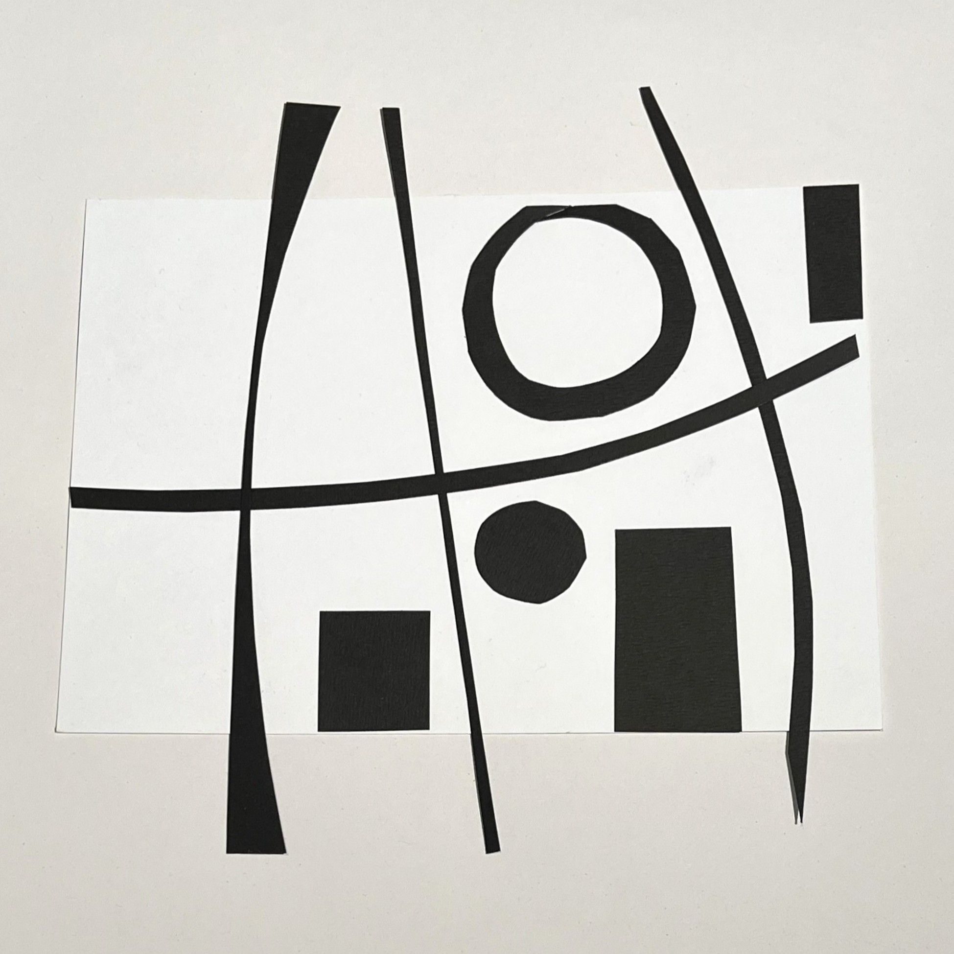 cut black card laid onto white paper. geometrical shapes and lines