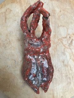 red stoneware object with rough fast glaze
