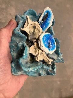 unfired coloured clay vessel holding studio bisque items for re-use