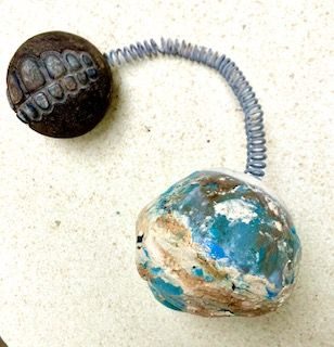 ceramic piece broken in kiln explosion attached to failed kiln element and expressive rubber ball