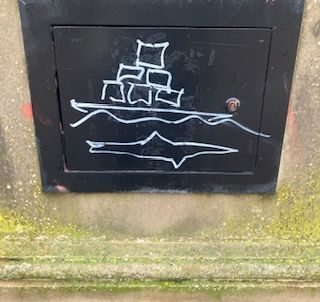 a white drawing on the black cover to an electric light on Margate sea front