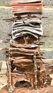 thin sheets of 3 different clays in a tower supporting many rail tickets