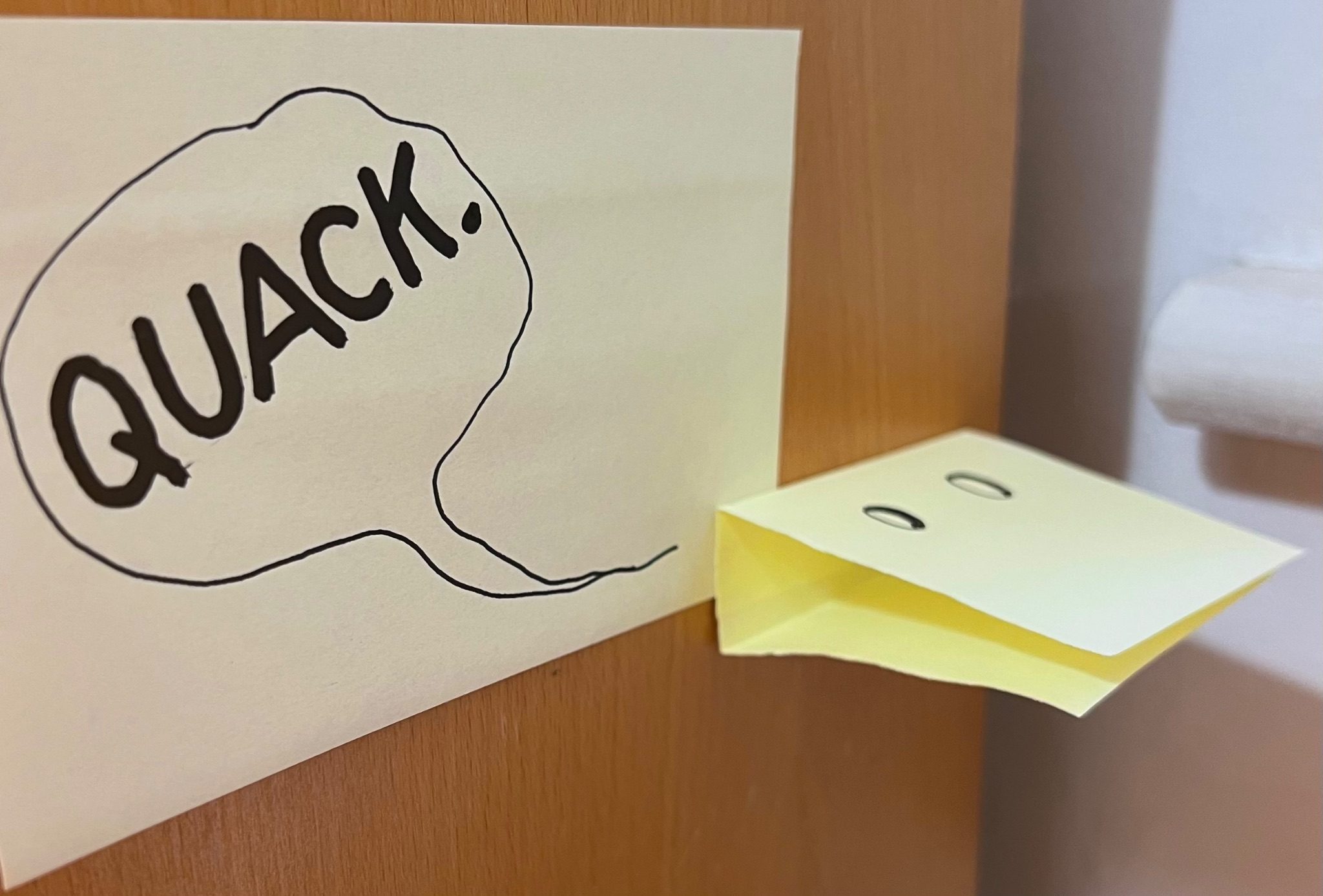 Post-it notes folded in such a way as to vaguely resemble a duck's beak, with additional pen 'nostrils' and a speech bubble saying 
