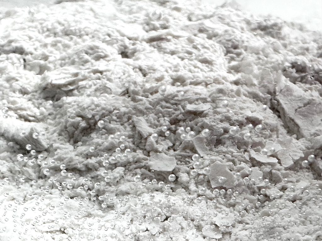 I photographed the clay flakes scattered into water and settled on the bottom after 24 hours. As the clay dissolved almost instantly, the water became cloudy; once the clay settled and all sediment came to rest, a mysterious, seabed-like surface emerged.