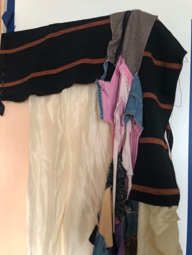 a larger multicoloured sewing work, in situ over a peach coloured door.