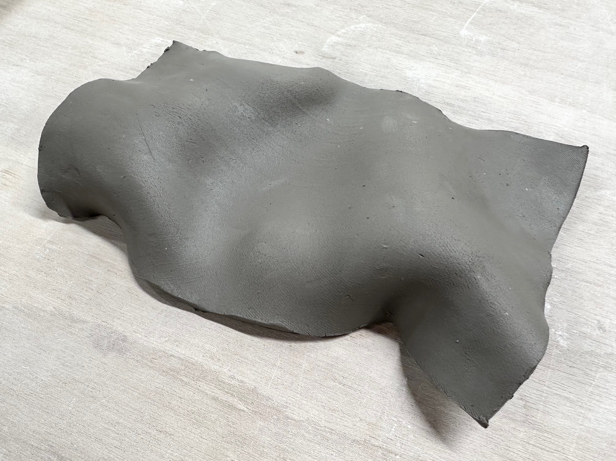 I cut a slab of clay into a rectangle and lifted and pressed the soft material, shaping it into a polyhedral form.