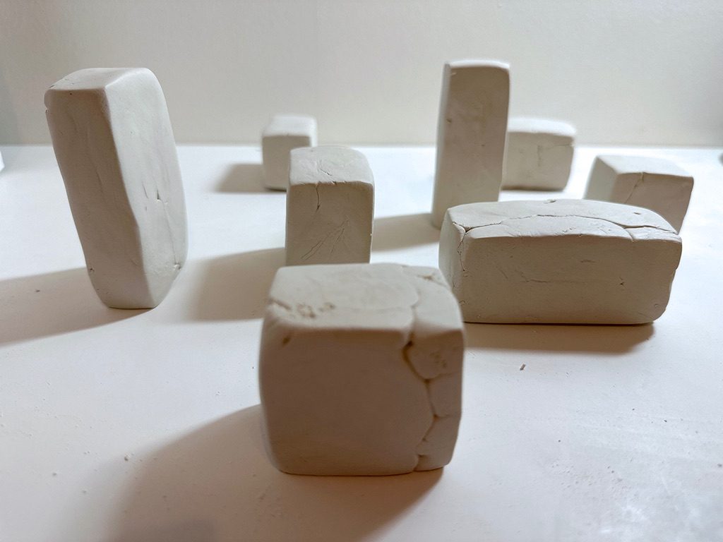I cut a clay mass, composed of reconstituted fragments from previous use, with a wire. I then struck each portion with a trowel to form a cube. Despite repeating the same operation, each cube took on a slightly different form.
