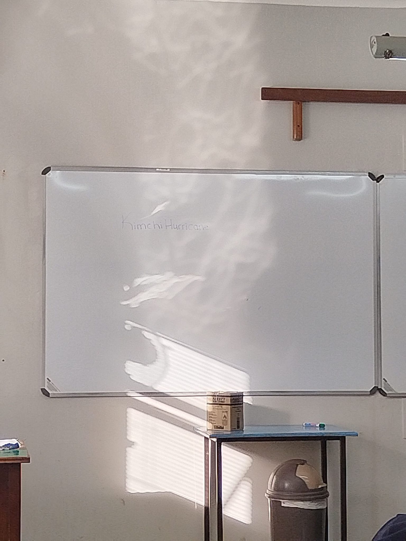 Light from a window shining across a classroom whiteboard