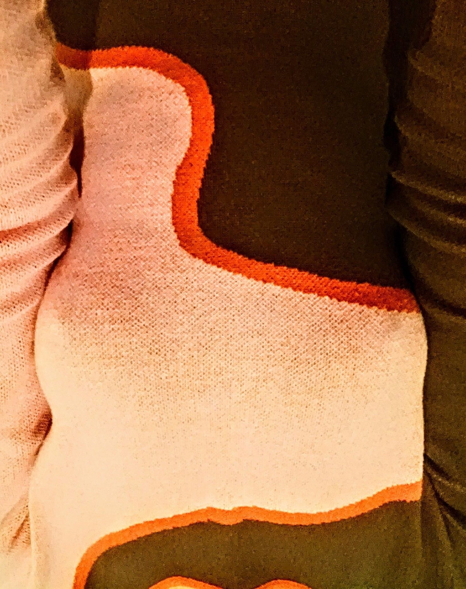 an image of a fabric torso with brown and pink colours and an orange wavy line