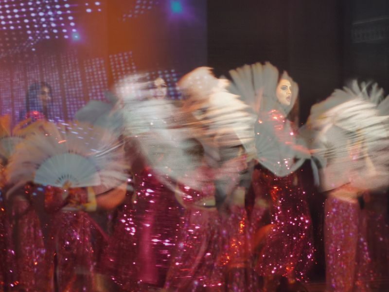 Double exposed dancers with fans and bright pink Indian dance costumes with white fans. The photographs are blurred with motion and bright pink colour.