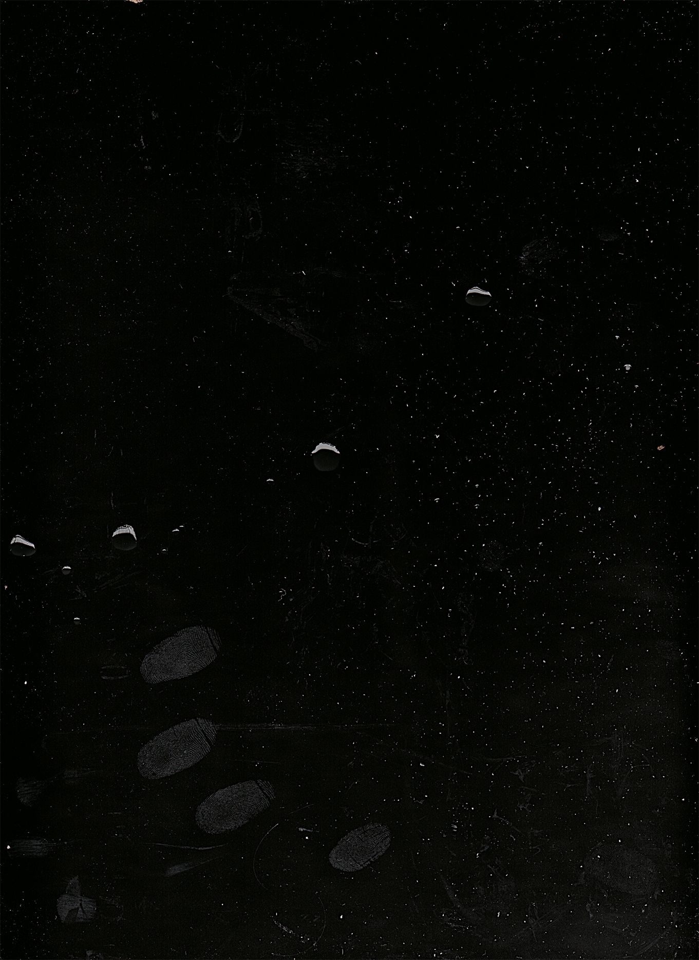 Black background with fingerprints, dust, and water droplets.