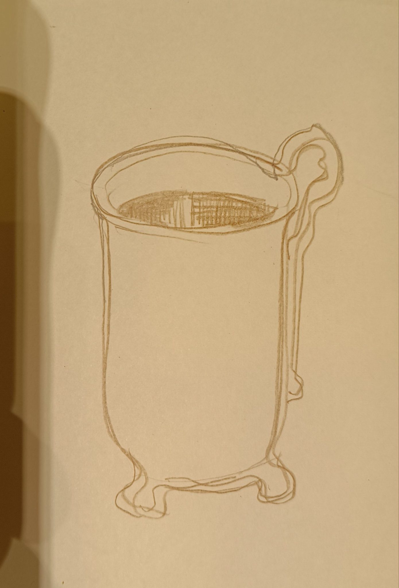 Drawing in brown pencil on cream paper of a long coffee cup with turned feet and looped handle